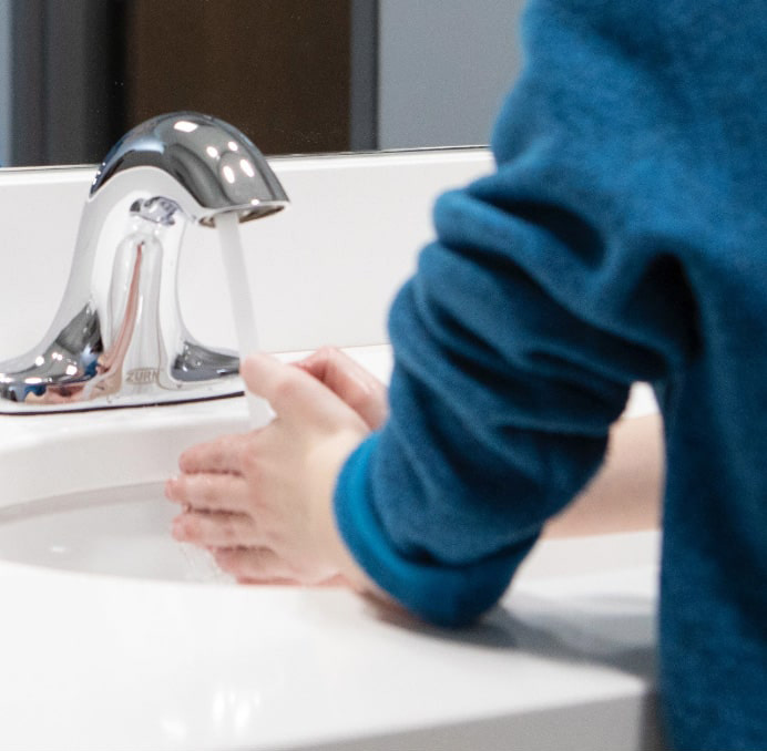 Person washing hands with Zurn faucet
